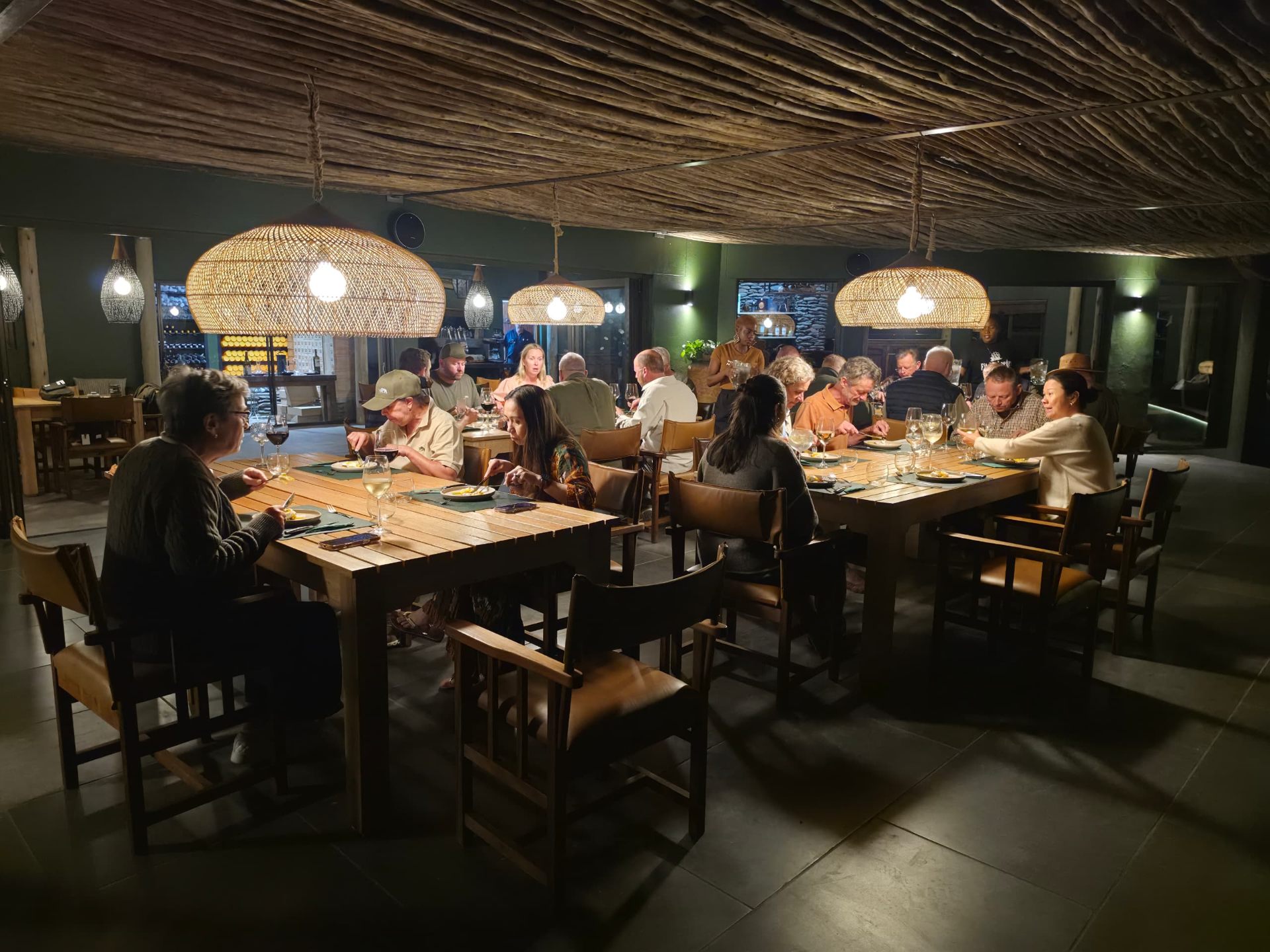 Guests dining under woven pendant lights